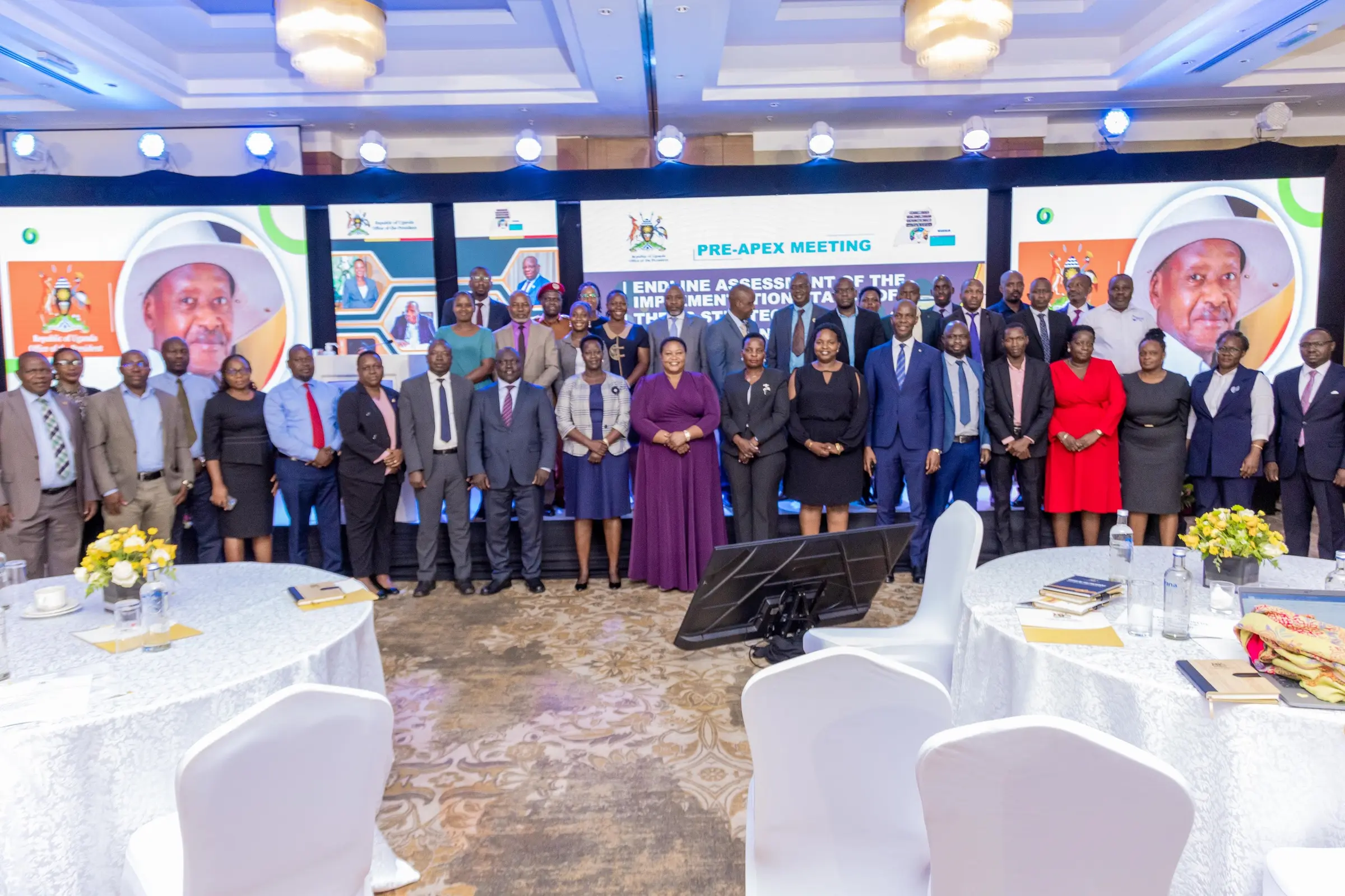 Group photo of delegates in front of the stage screens