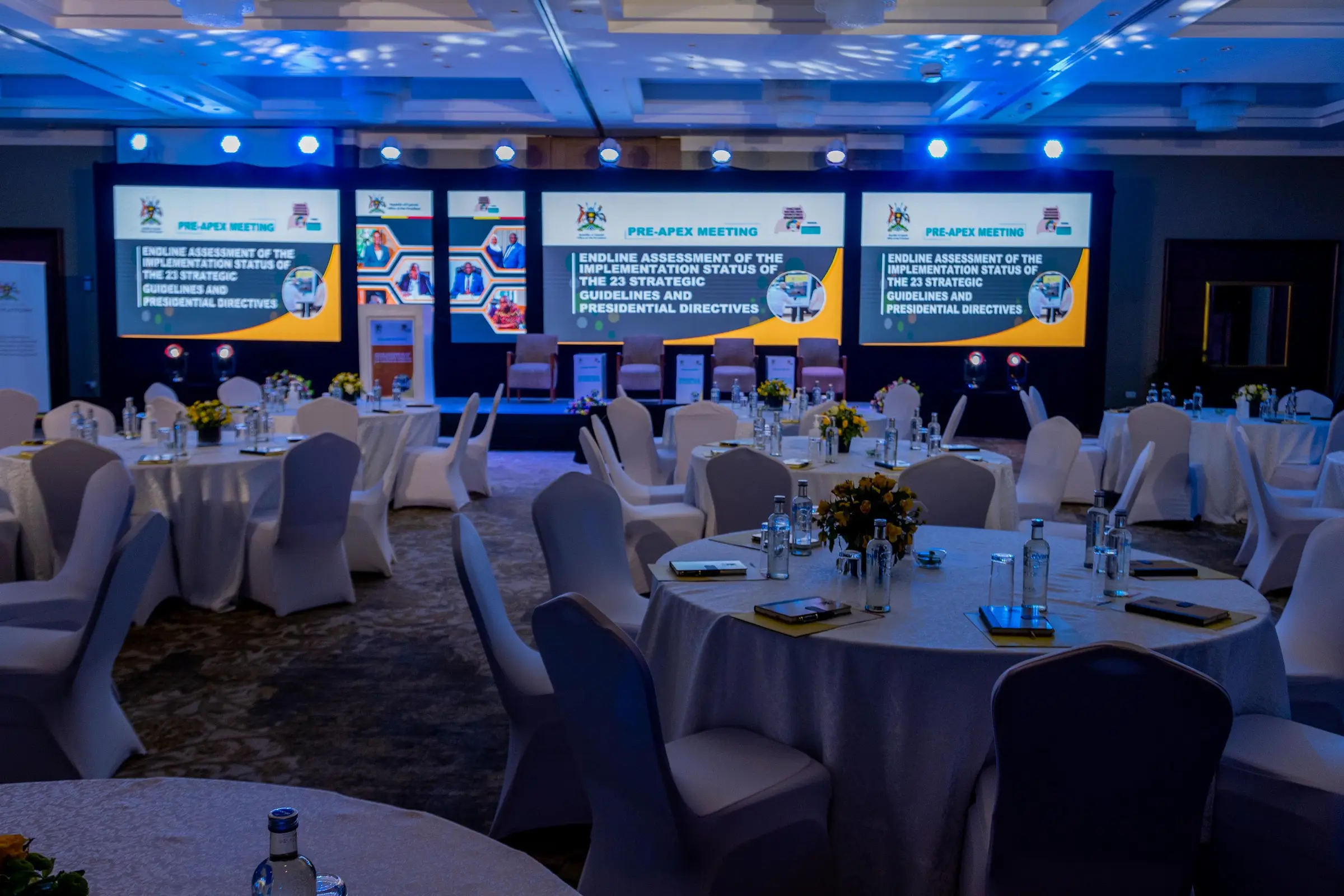 Ballroom set for the Pre-APEX Meeting, with a wall of LED screens behind the delegate tables