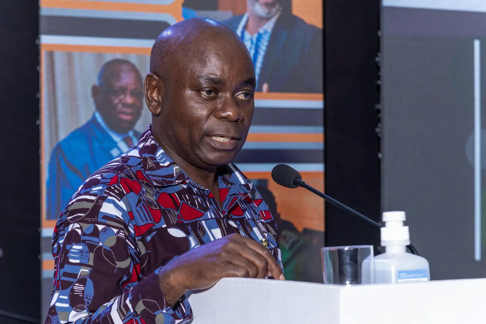 Speaker in a patterned shirt addressing the meeting